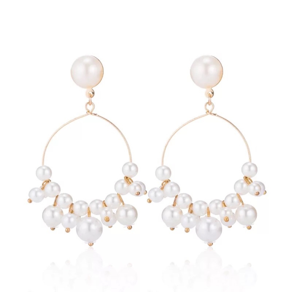 Gold and pearl dangle hoop earrings.